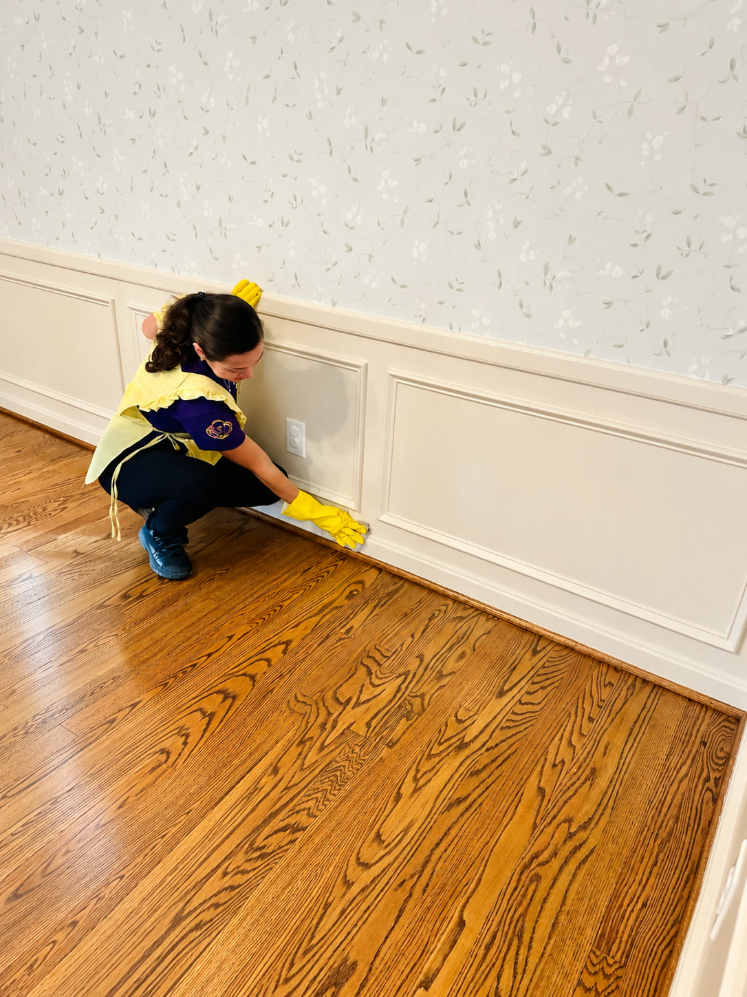 A team member wiping baseboards before a move-in