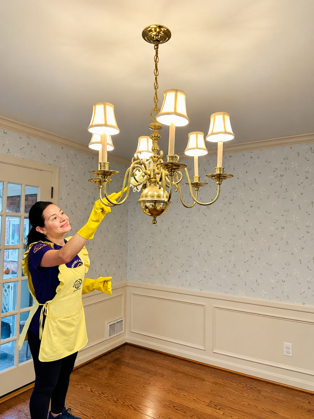 A team member dusting a chandelier during a move-out clean