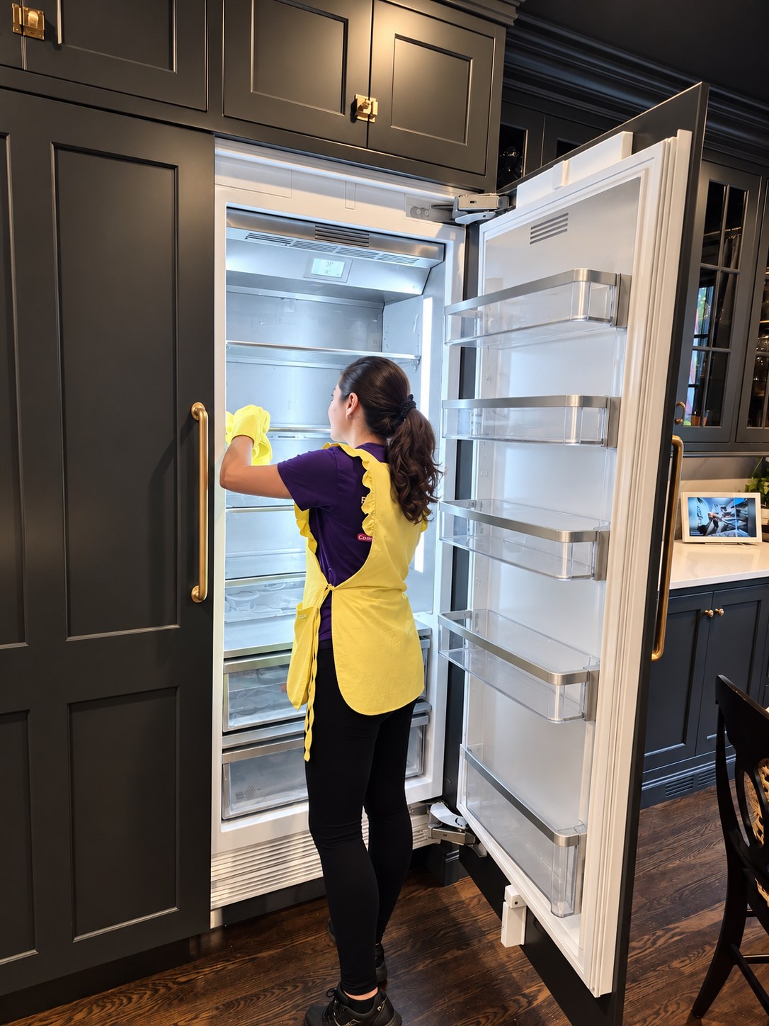 A Cleaning Cardinals team member deep-cleaning a built-in refrigerator
